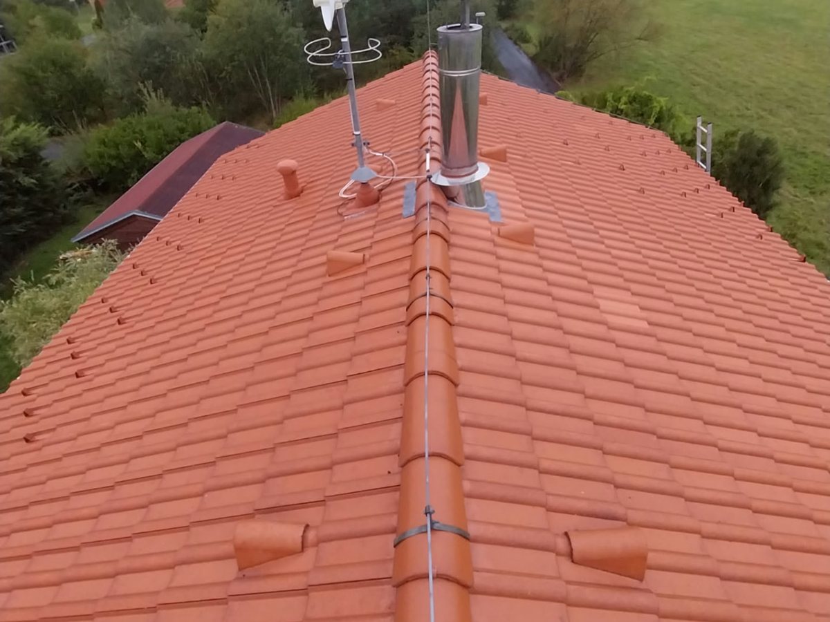 Pálená krytina po odstranění mechu u domu na okraji lesa